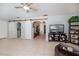 Open living area with tile flooring, ceiling fan, shelving, TV and barn doors to other rooms at 7231 Elyton Dr, North Port, FL 34287