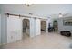 Spacious living area featuring tile floors, sliding barn doors, and a ceiling fan at 7231 Elyton Dr, North Port, FL 34287