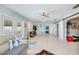 Open-concept living area with neutral tile flooring, ceiling fan, and multiple access points at 7231 Elyton Dr, North Port, FL 34287