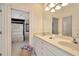Bathroom featuring a dual sink vanity, white cabinetry, and a view into the bedroom at 936 Hemingway Cir, Tampa, FL 33602