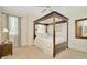 This bedroom features a lovely wood canopy bed, neutral walls, and an adjacent window with light-filtering curtains at 936 Hemingway Cir, Tampa, FL 33602