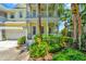 Charming yellow home with a two-car garage, double porches, white trim, and tropical landscaping at 936 Hemingway Cir, Tampa, FL 33602