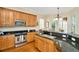 Well-appointed kitchen featuring wood cabinets, stainless steel appliances, and granite countertops at 936 Hemingway Cir, Tampa, FL 33602