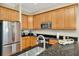 Charming kitchen featuring wood cabinets, granite countertops, and stainless steel refrigerator at 936 Hemingway Cir, Tampa, FL 33602