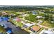 An aerial view of waterfront homes in a residential neighborhood with lush landscaping and private docks at 9582 Arsipe Cir, Port Charlotte, FL 33981
