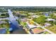 Aerial view showcasing waterfront homes with private docks, lush greenery, and water access at 9582 Arsipe Cir, Port Charlotte, FL 33981