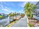 Waterfront view with a wooden dock and tropical landscaping in backyard at 9582 Arsipe Cir, Port Charlotte, FL 33981