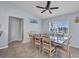 Bright dining room with a large window, ceiling fan, and a rustic wooden table perfect for Gathering gatherings at 9582 Arsipe Cir, Port Charlotte, FL 33981