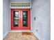 Inviting front entrance with red double doors and glass block transom window above at 9582 Arsipe Cir, Port Charlotte, FL 33981