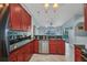 Well-lit kitchen featuring red cabinets, granite countertops, and an open design leading to the outdoor pool area at 9582 Arsipe Cir, Port Charlotte, FL 33981