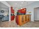 Bright kitchen featuring red cabinets, granite countertops, and bar seating area adjacent to the living room at 9582 Arsipe Cir, Port Charlotte, FL 33981