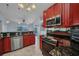 Red kitchen with granite counters, stainless appliances, and an open design that connects to other living spaces at 9582 Arsipe Cir, Port Charlotte, FL 33981