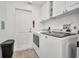 Bright laundry room with washer, dryer, and white cabinetry at 9582 Arsipe Cir, Port Charlotte, FL 33981