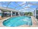 Enclosed pool with ladder and outdoor patio area overlooking the back yard at 9582 Arsipe Cir, Port Charlotte, FL 33981