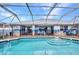 Large screened-in pool with steps and a full view of the backyard area and outdoor mural at 9582 Arsipe Cir, Port Charlotte, FL 33981