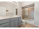 This bathroom features a shower-tub combo with glass doors and a vanity with blue cabinets and a white countertop at 101 N Marion Ct # 133, Punta Gorda, FL 33950