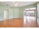 Bright living room featuring wood floors, ceiling fan, and sliding glass doors to the lanai at 10263 Shadow Run Cir, Punta Gorda, FL 33955