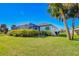 Spacious backyard with lush greenery and tropical plants surrounding the screened lanai at 122 Arrow Ln, Rotonda West, FL 33947