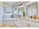 Elegant bathroom with a soaking tub, dual sinks, and granite countertops at 122 Arrow Ln, Rotonda West, FL 33947