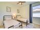 Inviting bedroom with twin beds, ceiling fan, modern art, and ample natural light at 122 Arrow Ln, Rotonda West, FL 33947