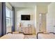 Bright bedroom with two beds, mounted TV, dresser, and a door leading to other rooms at 122 Arrow Ln, Rotonda West, FL 33947