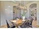 Dining room with stylish chandelier and wood table set for six at 122 Arrow Ln, Rotonda West, FL 33947