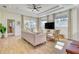 Sun-filled living room with tray ceiling, wood floors, and sliding glass doors at 122 Arrow Ln, Rotonda West, FL 33947