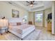Bright bedroom featuring tray ceilings, a ceiling fan, and neutral decor at 122 Arrow Ln, Rotonda West, FL 33947