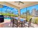 Covered outdoor dining area overlooking a screened pool, perfect for entertaining and relaxation at 122 Arrow Ln, Rotonda West, FL 33947
