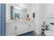 Bathroom with double sink vanity, white cabinetry, quartz countertop, and modern fixtures, reflecting natural light at 14257 Heritage Landing Blvd # 1115, Punta Gorda, FL 33955