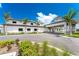 A grand entrance to a luxurious community building, highlighted by lush landscaping and palm trees at 14257 Heritage Landing Blvd # 1115, Punta Gorda, FL 33955