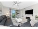 Open concept living room with a decorative fireplace, tiled floors, black leather couch, and sliding glass door at 14257 Heritage Landing Blvd # 1115, Punta Gorda, FL 33955
