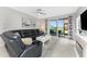 Living room with tiled floors, black leather couch, and sliding glass door leading to an outdoor patio at 14257 Heritage Landing Blvd # 1115, Punta Gorda, FL 33955