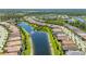 Residential area featuring homes with red tile roofs along a waterfront with lush green spaces in a planned community at 1470 Hyssop Loop, North Port, FL 34289