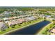Residential area featuring homes with red tile roofs along a waterfront with lush green spaces in a planned community at 1470 Hyssop Loop, North Port, FL 34289
