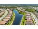 Residential area featuring homes with red tile roofs along a waterfront with lush green spaces in a planned community at 1470 Hyssop Loop, North Port, FL 34289