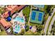 A perfect overhead shot features the pool, clubhouse, tennis courts, and outdoor lounge area at 1470 Hyssop Loop, North Port, FL 34289