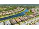 Residential area featuring homes with red tile roofs along a waterfront with lush green spaces in a planned community at 1470 Hyssop Loop, North Port, FL 34289