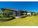 Beautiful backyard showcasing lush landscaping and a serene screened lanai on a sunny day at 1470 Hyssop Loop, North Port, FL 34289