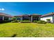 Well-manicured backyard featuring lush green lawn, mature landscaping, and a screened lanai for outdoor enjoyment at 1470 Hyssop Loop, North Port, FL 34289