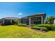Inviting backyard showcasing a manicured lawn, mature trees, and a screened lanai, perfect for relaxing and entertaining at 1470 Hyssop Loop, North Port, FL 34289