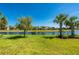 Beautiful backyard with serene lake view, mature trees and lush grass, offering a peaceful and scenic setting at 1470 Hyssop Loop, North Port, FL 34289
