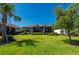 Spacious backyard featuring a well-maintained lawn, mature landscaping, and a screened lanai for outdoor living at 1470 Hyssop Loop, North Port, FL 34289