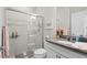 Bright bathroom features tiled shower with glass doors and vanity with gray countertop at 1470 Hyssop Loop, North Port, FL 34289
