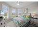 Bedroom with many windows, tropical patterned bedspread and a ceiling fan at 1470 Hyssop Loop, North Port, FL 34289