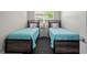 Bedroom with two beds, stylish decor, lamp and flamingo themed pillows at 1470 Hyssop Loop, North Port, FL 34289