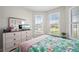A bright bedroom, tropical patterned bedspread and large windows with shutters at 1470 Hyssop Loop, North Port, FL 34289