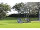 Scenic view of a bike rack on a green lawn surrounded by lush trees and bushes at 1470 Hyssop Loop, North Port, FL 34289