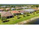 An attractive angle shows the neat lawn, tropical trees, and screened in porch, adjacent to a waterway at 1470 Hyssop Loop, North Port, FL 34289