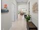 A hallway with tile floors and view into the living room of a bright and neutral colored home at 1470 Hyssop Loop, North Port, FL 34289